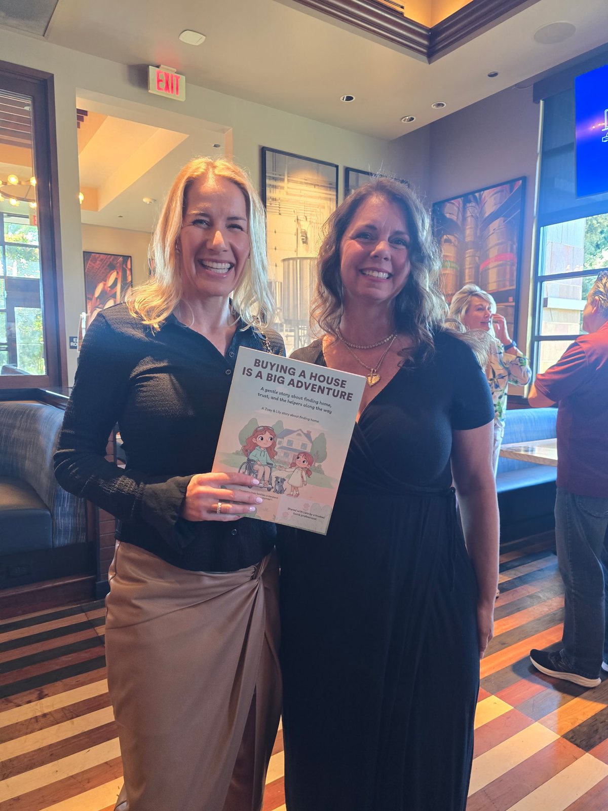 Real estate professionals with the book at a networking event